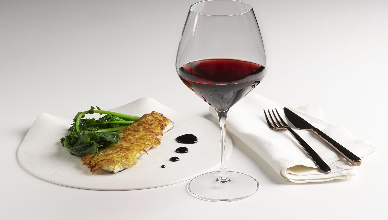 Bass filet with potato crust, red wine reduction and broccoli rabe