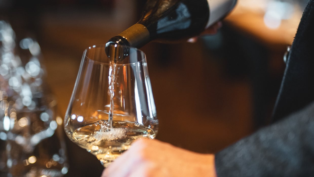 South Tyrolean white wine being poured from a bottle into a glass. ©IDM/Consorzio Vini Alto Adige/Mint Mediahouse
