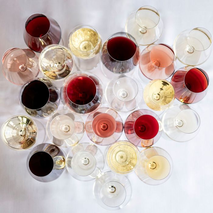 Many wine glasses arranged side by side, photographed from above. You can spot various wines: white, red, sparkling, and rosé, each served in a different glass.