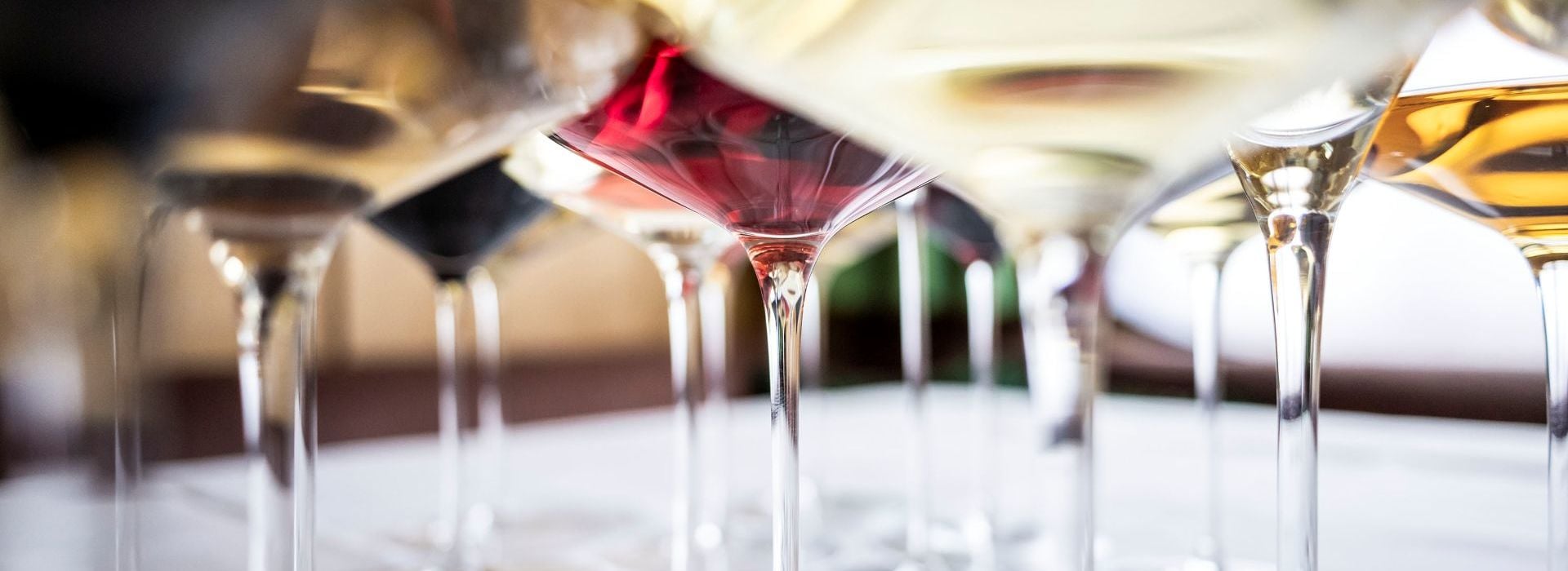 Many different glasses with various types of wine.
